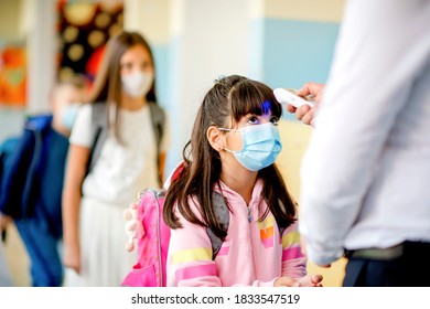 Teacher Doing Temperature Check On School Children 