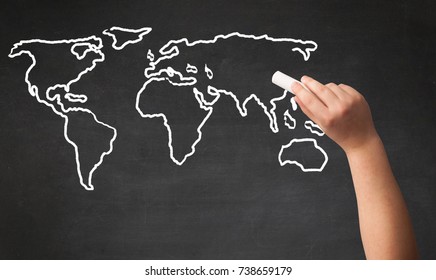 A teacher drawing the map of the world on a blackboard with a chalk - Powered by Shutterstock