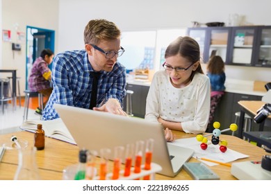 Teacher and elementary student at laptop in laboratory - Powered by Shutterstock