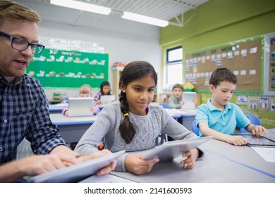 Teacher and elementary students using digital tablets