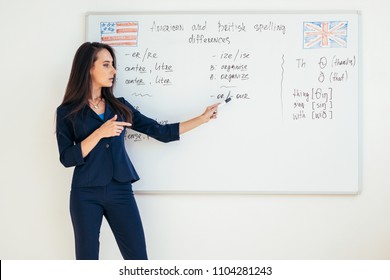 Teacher explaining differences between American and British spelling writing on whiteboard English language school
