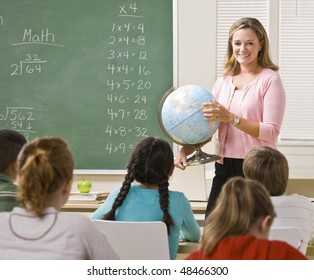 Teacher Explaining Globe To Students