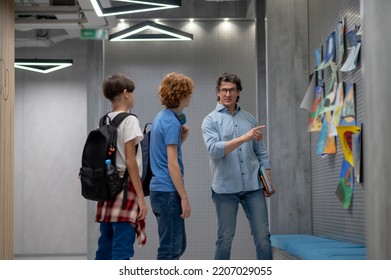 Teacher Explaining Something To His Pupils Based On Kids Artwork