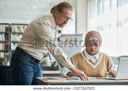 Teacher explaining topic to foreign student