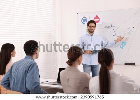 Teacher explaining traffic rules to audience during lesson in driving school