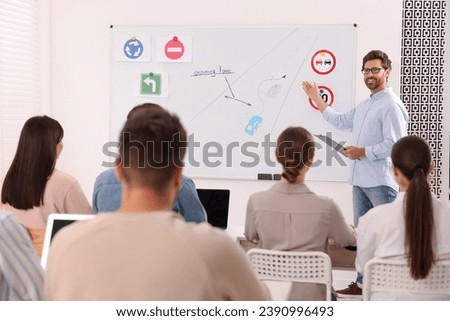 Teacher explaining traffic rules to audience during lesson in driving school
