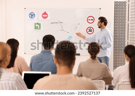 Teacher explaining traffic rules to audience during lesson in driving school