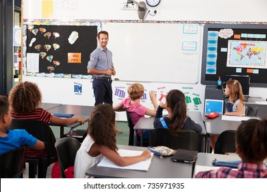 Teacher At Front Of Class In An Elementary School Lesson