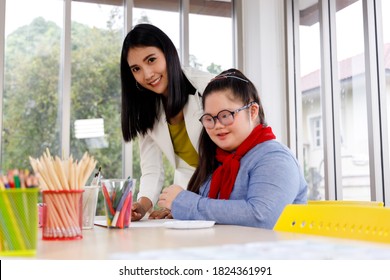 Teacher and girl with Down's syndrome in art class at school. - Shutterstock ID 1824361991
