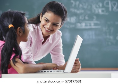 teacher and girl at laptop (horizontal) - Shutterstock ID 570197581
