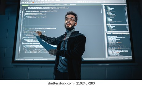 Teacher Giving Computer Science Lecture To Diverse Multiethnic Group Of Female And Male Students In Dark College Room. Projecting Slideshow With Programming Code. Explaining Information Technology.