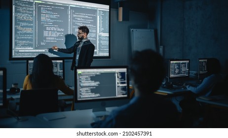 Teacher Giving Computer Science Lecture To Diverse Multiethnic Group Of Female And Male Students In Dark College Room. Projecting Slideshow With Programming Code. Explaining Information Technology.