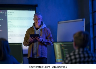 Teacher Giving Computer Science Lecture To Young Students In Dark Room. Room. Explaining Information Technology.