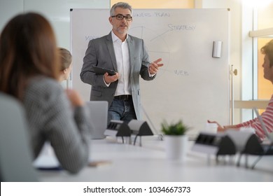 Teacher Giving Economics Class, Using Whiteboard