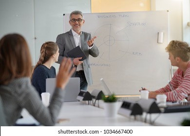 Teacher Giving Economics Class, Using Whiteboard