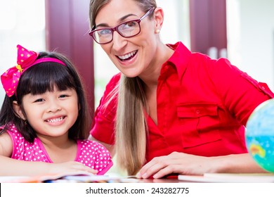 Teacher giving language lessons and doing homework to Chinese child