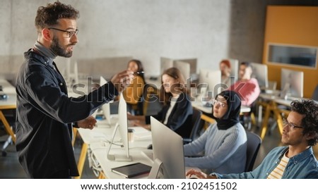 Teacher Giving Lesson to Diverse Multiethnic Group of Female and Male Students in College Room, Learning New Academic Skills on a Computer. Lecturer Shares Knowledge with Smart Young Scholars.