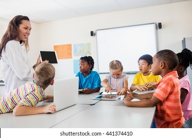 A Teacher Giving Lesson With New Technology In Classroom