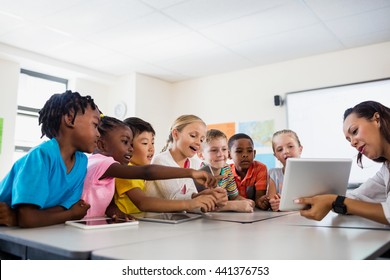 A Teacher Giving Lesson With Tablet Computer In Classroom