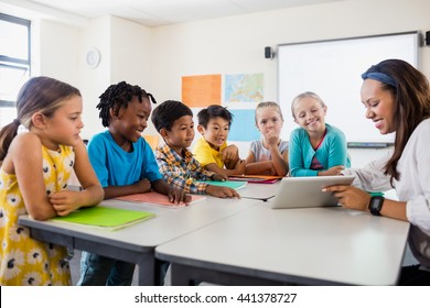 A Teacher Giving Lesson With Tablet Computer In Classroom