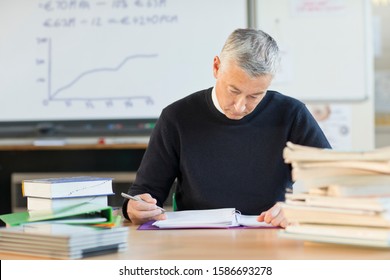 Teacher Grading Homework In Classroom