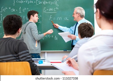 Teacher With A Group Of High School Students In Classroom