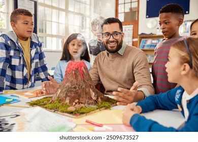 Teacher and group of primary children learning about volcanos at science project. Group of elementary students feeling surprised on seeing volcanic eruption in class with teacher during science class. - Powered by Shutterstock