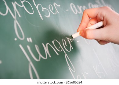 Teacher Hand Writing Grammar Sentences On Blackboard Background