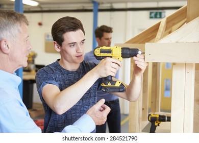 Teacher Helping College Student Studying Carpentry