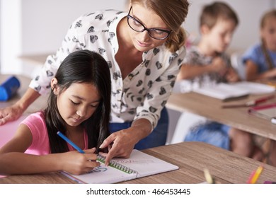 Teacher helping girl in homework
