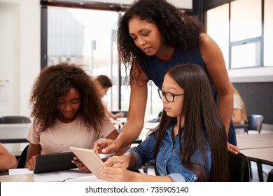 Teacher helping high school students with technology - Shutterstock ID 735905140