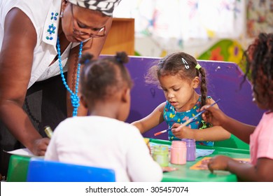 Teacher Helping Kids In A Preschool Class, Close Up