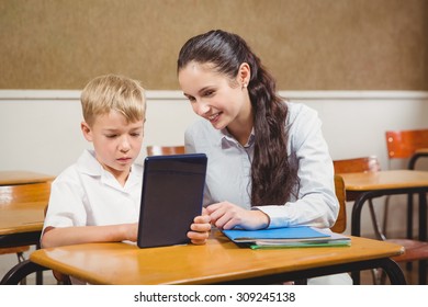 Teacher Helping A Student In Class At The Elementary School