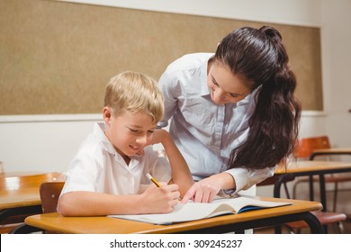 Teacher Helping A Student In Class At The Elementary School