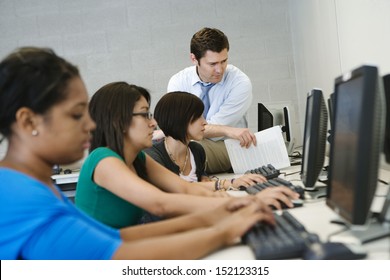 Teacher Helping Student In Computer Lab