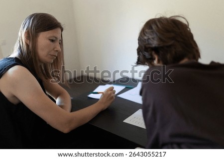 Teacher helping student with learning difficulties during private lesson