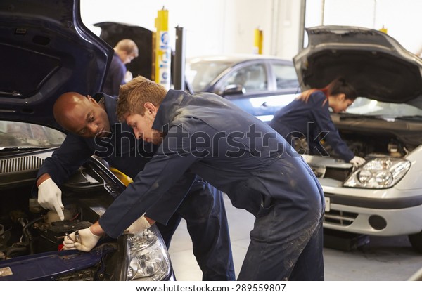 Teacher\
Helping Student Training To Be Car\
Mechanics