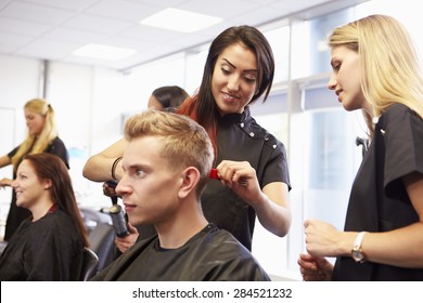 Teacher Helping Students Training To Become Hairdressers