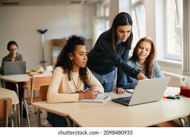 IT teacher and her students using laptop during computer class in high school.  - Powered by Shutterstock