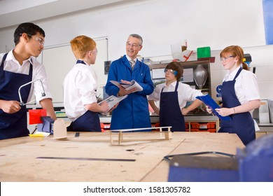 Teacher with high school students in design and technology class