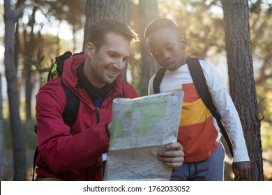 Teacher And Kid Reading Map In Forest