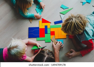 teacher and kids play with puzzle, doing tangram