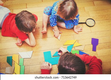 teacher and kids playing with geometric shapes - Shutterstock ID 713642749