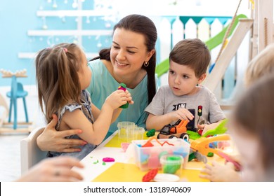 Teacher With Kids Working With Plasticine At Kindergarten Or Playschool