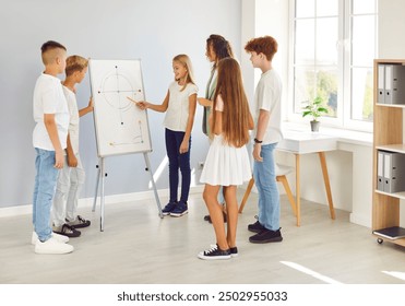 Teacher is leading a lesson in a school classroom, surrounded by a group of attentive students children. Energy of learning, as the pupils engage with the material and the teacher guides them. - Powered by Shutterstock