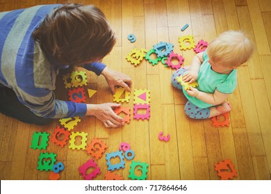 teacher and little baby playing with number puzzle