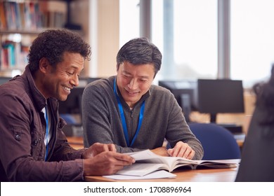 Teacher With Mature Male Adult Student Sitting At Table Working In College Library - Powered by Shutterstock