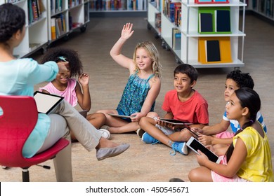 Teacher pointing at arm raised student in library - Powered by Shutterstock