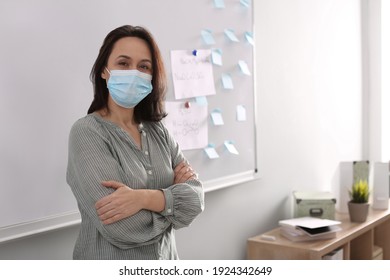 Teacher with protective mask near board in classroom. Reopening after Covid-19 quarantine - Powered by Shutterstock