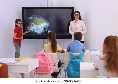 Teacher and pupil using interactive board in classroom during lesson - Powered by Shutterstock